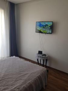 a bedroom with a bed and a flat screen tv on the wall at Beach-Side 2-BR Oasis with Private Pool & Parking in Casablanca