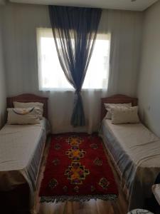 a bedroom with two beds and a window at Beach-Side 2-BR Oasis with Private Pool & Parking in Casablanca +18 photos