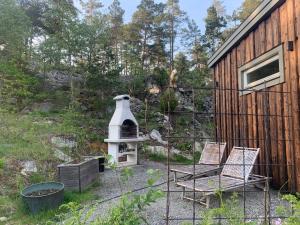 un patio con 2 sillas y una casa de aves en Fullt utrustat Minihus på landet, en Västerhaninge
