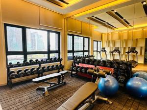 een fitnessruimte met veel fitnessapparatuur en ramen bij Agile Bukit Bintang Suites TRX in Kuala Lumpur +46 foto's