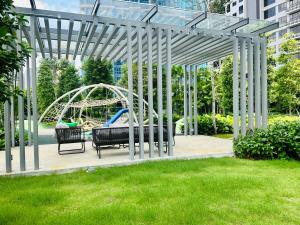 een pergola met een speeltuin in een tuin bij Agile Bukit Bintang Suites TRX in Kuala Lumpur