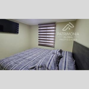サンティアゴにあるPatrimonia Hostal Los Gladiolosのベッドとテレビのある看板のある寝室