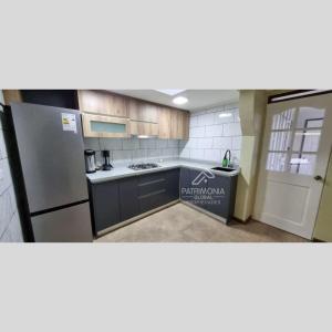 サンティアゴにあるPatrimonia Hostal Los Gladiolosのキッチン(冷蔵庫、カウンタートップ付)