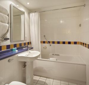 a bathroom with a sink and a tub and a toilet at Lancaster Gate Hotel in London