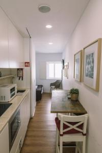 a small kitchen with a table and a microwave at Casa da Maria Alfama in Lisbon