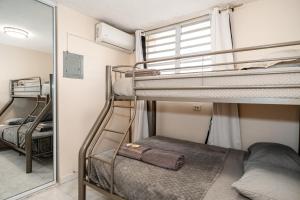 Zimmer mit 2 Etagenbetten und einem Spiegel in der Unterkunft Oasis in the South of the Island with FREE parking and laundry in Ponce