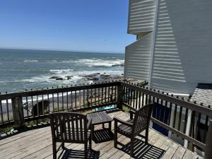 two chairs and a table on a deck overlooking the ocean at The Oceanfront Inn in Shelter Cove