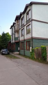 a green and white building with a car parked next to it at Apartment Vecliepaja in Liepāja