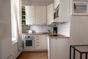 eine weiße Küche mit weißen Schränken und einem Waschbecken in der Unterkunft 2ndhomes Kamppi Apartments 1 in Helsinki