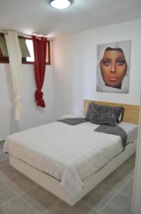 a bedroom with a bed with a picture of a black woman at Apartment mit schöner Aussicht und Balkon in San Marcos