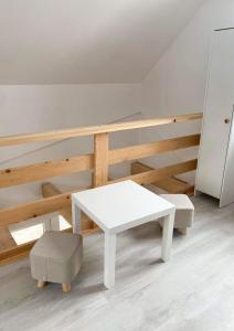 a white table and a stool in a room at Domek Na Wzgórzu in Dubiecko +13 photos