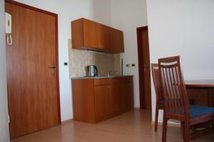 a kitchen with wooden cabinets and two chairs and a door at Apartments Riva in Medulin