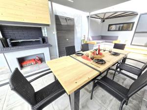 a dining room with a table and a fireplace at Seashell tiny house in Nea Kalikratia