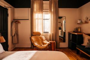 Habitación con silla, cama y ventana en Somewhere Inn Collingwood, en Collingwood