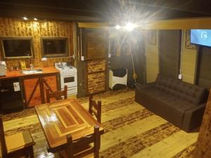 ein Wohnzimmer mit Sofa und Tisch in der Unterkunft Cabaña Trapecio in San Carlos de Bariloche