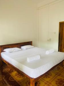 1 cama con 2 almohadas en una habitación en ZIMBAY Guest House, en Arugam Bay