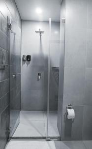 um chuveiro com uma porta de vidro na casa de banho em Hotel Rupa Rupa em Tingo María