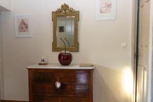 un jarrón en un tocador con un espejo en la pared en VILLA PROVENCALE FACE AU LUBERON, en Cabrières-dʼAvignon