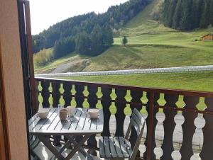 a table on a balcony with a view of a mountain at Charmant studio vu sur la montagne in Le Biot