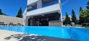 a swimming pool in front of a house at Villa Primavera in Novalja