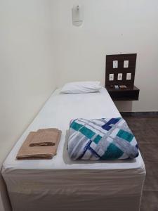 Una cama con dos toallas encima. en HOTEL TABARANA, en Ubarana