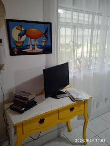 un escritorio con un ordenador encima en MINHA CASA,SUA CASA en São Bento do Sapucaí