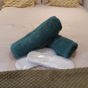 une paire de serviettes vertes sur un lit dans l'établissement Le Hub - Roundhay Leeds - 1-Bed Studio Apartment, à Leeds