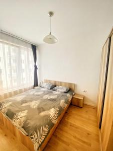 sypialnia z łóżkiem i oknem w obiekcie Sunflower Apartments w Prisztinie