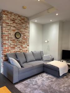 uma sala de estar com um sofá e uma parede de tijolos em Säynätsalo Apartment em Säynätsalo