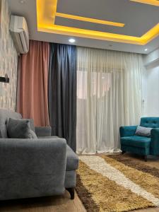 a living room with a couch and two chairs at شقة مفروشة بالشيخ زايد كمبوند جنه زايد in Sheikh Zayed
