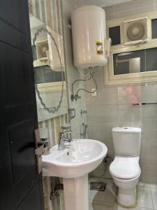 a bathroom with a toilet and a sink at شقة مفروشة بالشيخ زايد كمبوند جنه زايد in Sheikh Zayed