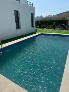 a swimming pool in front of a house at Villa Helios in Gürece