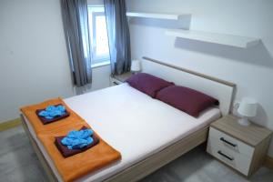 a bedroom with a bed with two blue pillows on it at Hostel Pirano in Piran