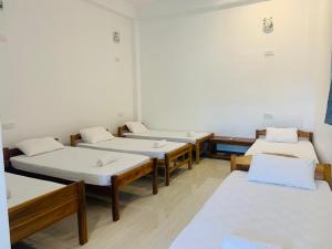 Un grupo de 4 camas en una habitación en ZIMBAY Guest House, en Arugam Bay