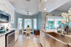 cocina con armarios blancos y comedor con mesa en The Albatross on 14th, en Cabo Coral