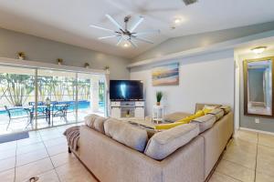 Una sala de estar con un sofá y un televisor de pantalla plana. en The Albatross on 14th, en Cabo Coral