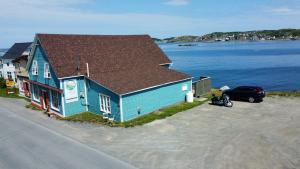 a blue house with a car parked in front of it at Jagged Rocks in Twillingate