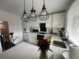 una cocina con una mesa con un jarrón de flores en Clapham Oasis: Relax & Explore! en Londres