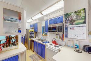 a kitchen with blue cabinets and white appliances at Long Island Village Unit 658 in Port Isabel
