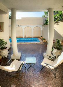 a swimming pool in a building with chairs and a swimming pool at La casa frente al parque in Mendoza