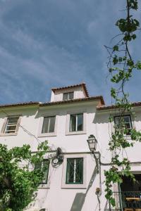 um edifício branco com janelas e uma luz de rua em Casa da Maria Alfama em Lisboa