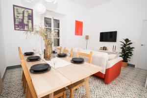 comedor con mesa de madera y sofá en California Apartament Dos de Mayo, en Sevilla