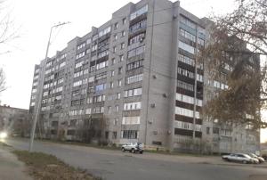 een groot gebouw met een auto voor de deur bij 4х комнатные апартаменты in Pavlodar
