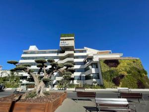 a building with a green wall on the side of it at Hotel Cap Negret in Altea
