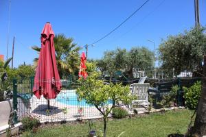 豐當的住宿－Quinta de São Marcos，两个红色遮阳伞坐在游泳池旁