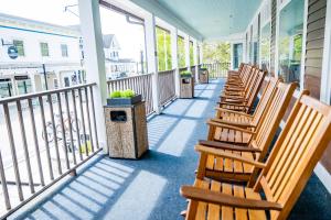 rząd drewnianych krzeseł siedzących na ganku w obiekcie Lake View Hotel w mieście Wyspa Mackinac