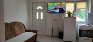 a living room with a couch and a tv on the wall at Apartman in Nikšić