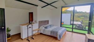 a bedroom with a bed and a large window at Glamping Villa Transito in Machetá