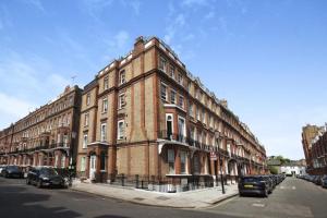 un gran edificio de ladrillo en el lateral de una calle en Lovely South Kensington Flat en Londres