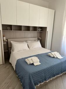 ein Schlafzimmer mit einem Bett mit zwei Handtüchern darauf in der Unterkunft Casa Verga in Monopoli